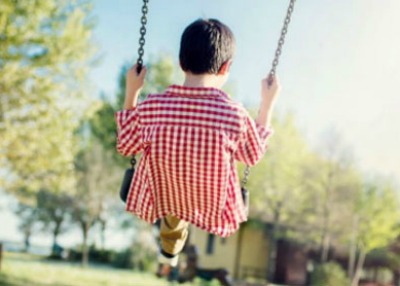 Bambino cade dall'altalena, senza maniglia di appoggio, di un...